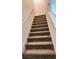 Fully carpeted staircase features a bright white railing, ensuring a safe and stylish transition between floors at 13712 Summerport Village Pkwy, Windermere, FL 34786