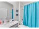 Bathroom featuring a shower with a blue curtain, toilet, sink with vanity, and wall art at 4348 Quote St, Kissimmee, FL 34746