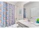 Bathroom featuring a shower with a blue curtain, toilet, sink with vanity, and wall art at 4348 Quote St, Kissimmee, FL 34746