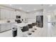 Modern kitchen features quartz countertops, stainless steel appliances, and an island with seating at 4348 Quote St, Kissimmee, FL 34746