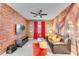 Themed living room featuring a red brick accent wall, leather sofa, and carpet flooring at 4348 Quote St, Kissimmee, FL 34746