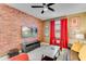 Cozy living room with a brick accent wall, ceiling fan, and comfortable seating at 4348 Quote St, Kissimmee, FL 34746
