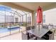 Outdoor patio area with a dining set and an umbrella near a screened-in pool and spa at 4348 Quote St, Kissimmee, FL 34746