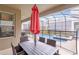Outdoor patio area with a dining set and an umbrella near a screened-in pool and spa at 4348 Quote St, Kissimmee, FL 34746