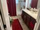 Bathroom featuring vanity with dark cabinetry, complementary red accents, and a tub and shower combination at 806 Ebb Tide Ln, Poinciana, FL 34759