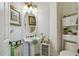 Bright bathroom with pedestal sink, decorative storage, and neutral wall color at 806 Ebb Tide Ln, Poinciana, FL 34759