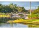 Scenic pond view featuring a stone bridge, lush landscaping, and serene water features at 806 Ebb Tide Ln, Poinciana, FL 34759