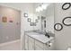 Bright bathroom featuring a large mirror, gray countertop, white cabinetry and modern fixtures at 8541 Spyglass Ln, Davenport, FL 33896