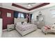 Elegant bedroom showcasing a tufted headboard, mirrored nightstands, and tray ceiling detail at 8541 Spyglass Ln, Davenport, FL 33896