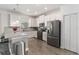 Well-lit kitchen boasts white cabinetry, modern appliances, and stylish pendant lighting at 8541 Spyglass Ln, Davenport, FL 33896