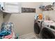 Bright laundry room featuring a front-loading washer and dryer and shelving for storage at 8541 Spyglass Ln, Davenport, FL 33896