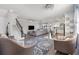 A spacious living room featuring wood floors, a comfortable grey sofa, and a staircase at 8541 Spyglass Ln, Davenport, FL 33896
