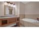 Bathroom with a large soaking tub and vanity featuring granite counters at 2774 Bella Vista Dr, Davenport, FL 33897