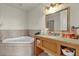 Bright bathroom featuring a soaking tub and vanity with a granite countertop at 2774 Bella Vista Dr, Davenport, FL 33897