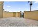 Paved patio area enclosed by a stucco wall with a dark metal access gate to the rear of the property at 2774 Bella Vista Dr, Davenport, FL 33897