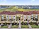 A row of tan two-story townhomes boast red-tiled roofs, small yards, and lush landscaping at 2774 Bella Vista Dr, Davenport, FL 33897