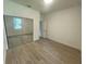 Bright bedroom featuring mirrored closet doors and wood-look tile floors at 1730 Old Apopka Rd, Apopka, FL 32703