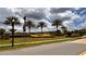Attractive community entrance showcasing lush landscaping, palm trees, and elegant signage for a welcoming arrival at 1515 Carey Palm Cir, Kissimmee, FL 34747