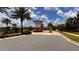 Picturesque gated community entrance with a charming guardhouse, lush palm trees, and well-maintained landscaping at 1515 Carey Palm Cir, Kissimmee, FL 34747
