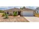 Tan one-story house with a two-car garage and landscaping at 340 Elderberry Ct, Kissimmee, FL 34759