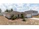 One-story house with a light tan exterior, landscaping, and a two-car garage at 340 Elderberry Ct, Kissimmee, FL 34759