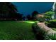 Landscaped backyard at night with lighting at 9210 Southern Breeze Dr, Orlando, FL 32836
