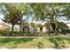Tan house with lush landscaping and palm trees in the front at 9210 Southern Breeze Dr, Orlando, FL 32836
