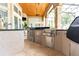 Outdoor kitchen with stainless steel appliances and a built-in refrigerator at 9210 Southern Breeze Dr, Orlando, FL 32836