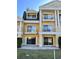 Elegant yellow townhome featuring balconies, columns, and manicured lawn at 1322 Seven Eagles Ct # 101, Reunion, FL 34747
