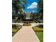 Beautiful water fountain on a brick path leading to a stately building under a blue sky at 1322 Seven Eagles Ct # 101, Reunion, FL 34747