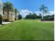 View of the lush green golf course surrounded by palm trees and manicured landscaping at 1322 Seven Eagles Ct # 101, Reunion, FL 34747