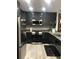 Contemporary kitchen featuring dark cabinets, granite countertops, and stainless appliances at 1322 Seven Eagles Ct # 101, Reunion, FL 34747