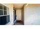 View of the covered front porch featuring an open front door, tile floor and exterior sconce lighting at 5317 Micco St, Kissimmee, FL 34746