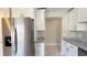 Efficient kitchen layout with stainless steel fridge, granite counters, and white cabinets at 5317 Micco St, Kissimmee, FL 34746