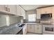 Bright kitchen featuring white cabinets, granite countertops, modern appliances, and a breakfast bar at 5317 Micco St, Kissimmee, FL 34746