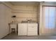 Small laundry room featuring a utility sink, storage shelves and a washer and dryer at 5317 Micco St, Kissimmee, FL 34746