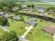 Aerial view of a waterfront home with a pool, manicured lawn, and access to a canal leading to the lake at 720 Shore Drive, Kissimmee, FL 34744