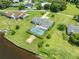 Aerial view of a single-story home with a screened-in pool, landscaped yard and canal access at 720 Shore Drive, Kissimmee, FL 34744