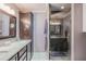 Bathroom features double sinks, granite countertops, a dark wood cabinet, and a glass enclosed shower for a luxurious experience at 720 Shore Drive, Kissimmee, FL 34744