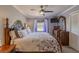 Cozy bedroom features a wooden four-poster bed with floral bedding, ceiling fan, and a dresser with a large decorative mirror at 720 Shore Drive, Kissimmee, FL 34744