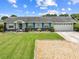 Charming single-story home with stone accents, shutters, well-manicured lawn, and an attached two car garage at 720 Shore Drive, Kissimmee, FL 34744