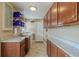 Well-organized laundry room features tile floors, granite counters, wood cabinets, and ample storage at 720 Shore Drive, Kissimmee, FL 34744