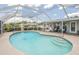 Sparkling blue in-ground pool surrounded by a spacious concrete patio with outdoor seating, perfect for relaxation and entertainment at 720 Shore Drive, Kissimmee, FL 34744