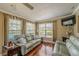 Cozy sun room with hardwood floors, comfortable couches, and views of the pool and patio at 720 Shore Drive, Kissimmee, FL 34744
