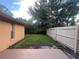 Backyard featuring a concrete patio, green grass, a privacy fence, and a mature shade tree at 3180 Owassa Ct, Kissimmee, FL 34746
