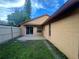 The backyard features a concrete patio with sliding glass doors leading inside, green grass, and a white fence at 3180 Owassa Ct, Kissimmee, FL 34746