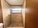 Tiled bathroom featuring a walk-in shower with updated fixtures and a window for natural light at 3180 Owassa Ct, Kissimmee, FL 34746