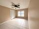 Cozy bedroom features tile flooring, ceiling fan, and a bright window at 3180 Owassa Ct, Kissimmee, FL 34746