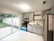 Modern kitchen with stainless steel appliances, gray cabinets, and a sliding glass door to the backyard at 3180 Owassa Ct, Kissimmee, FL 34746