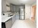 This kitchen showcases stainless steel appliances, gray cabinets, and a clean countertop design for a modern feel at 3180 Owassa Ct, Kissimmee, FL 34746